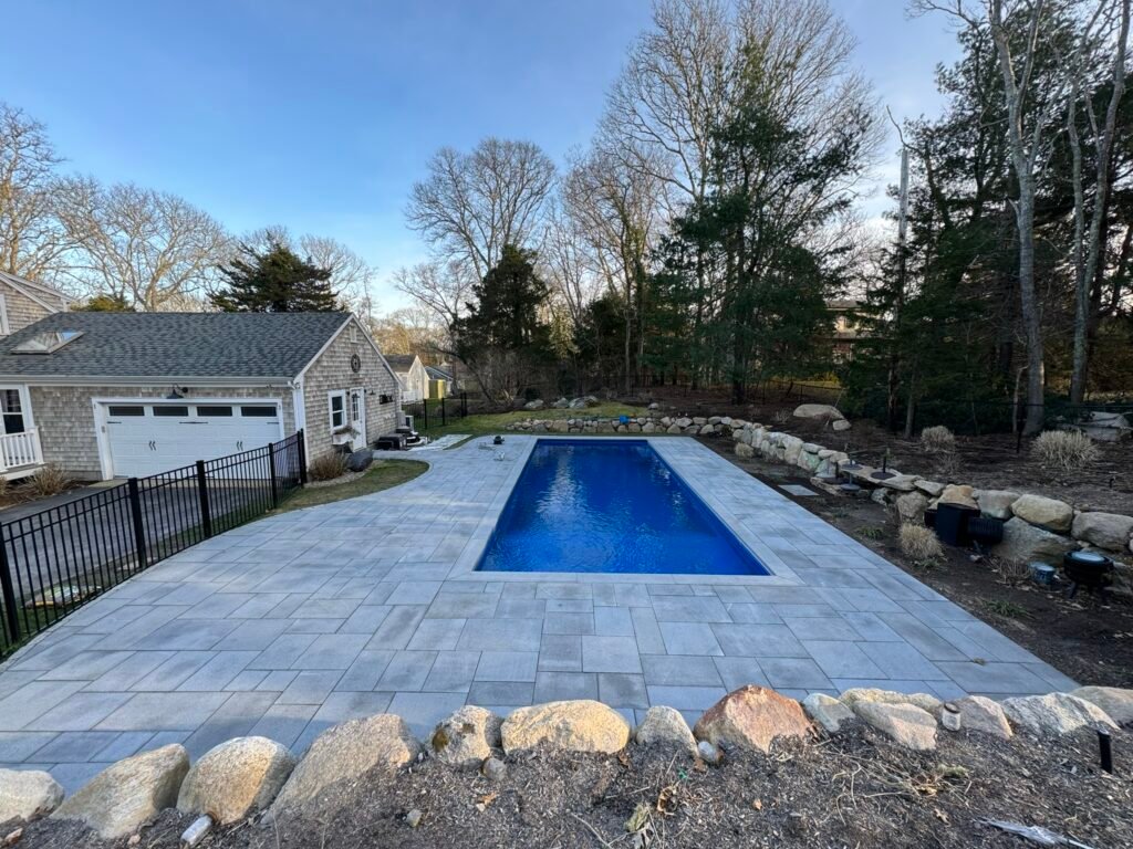 Paver pool deck surrounding an in-ground pool on Cape Cod