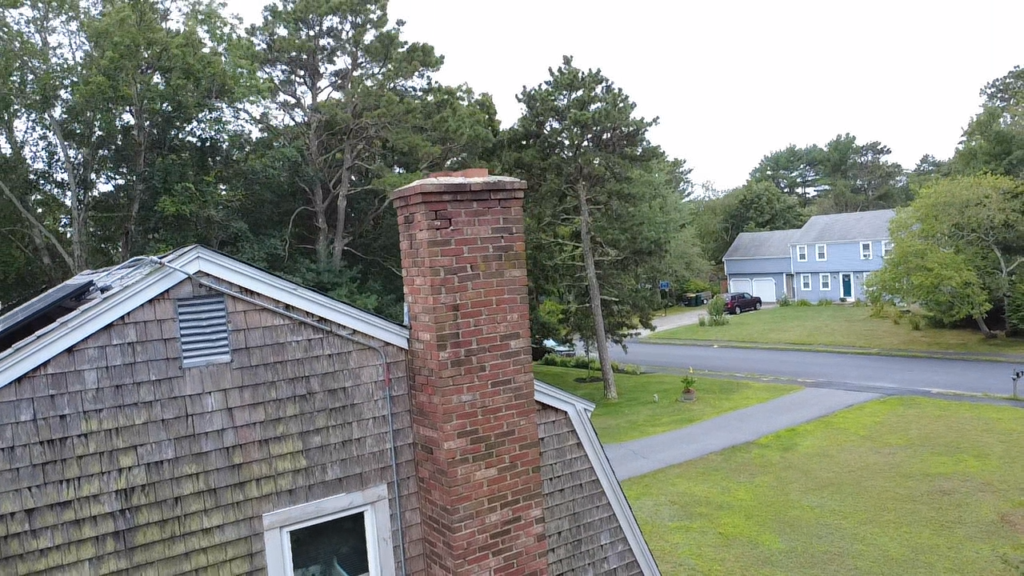 Drone view of a brick chimney and roof during a Bridi Masonry inspection on Cape Cod