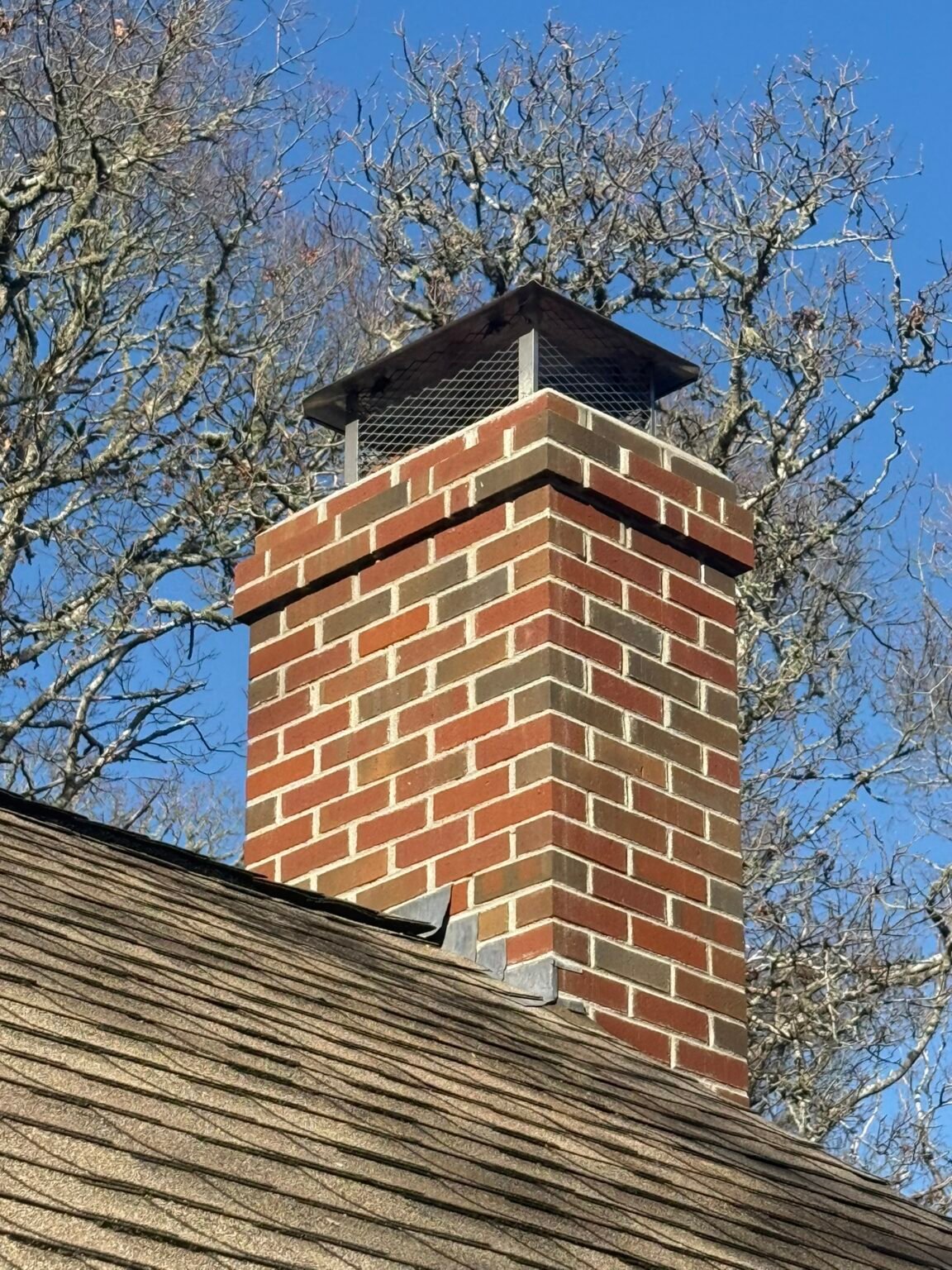 After: rebuilt chimney with corbelled top course and new black cap