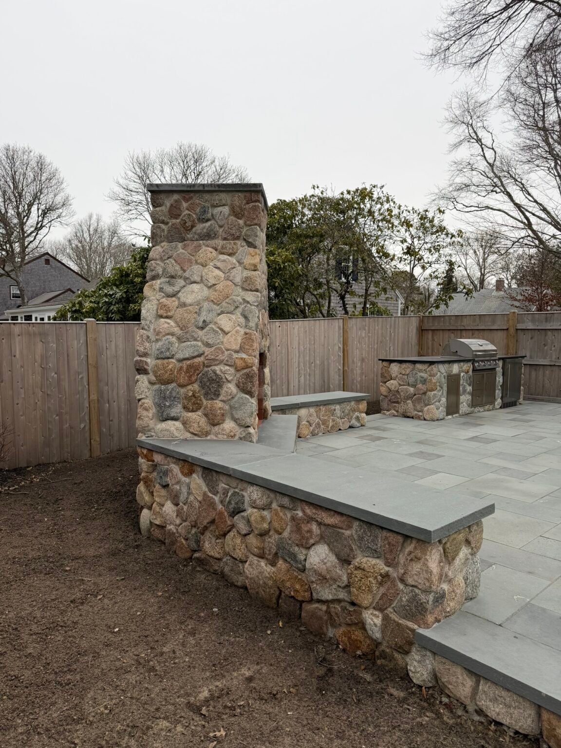 Outdoor fireplace and kitchen built by Bridi Masonry in Cape Cod, MA