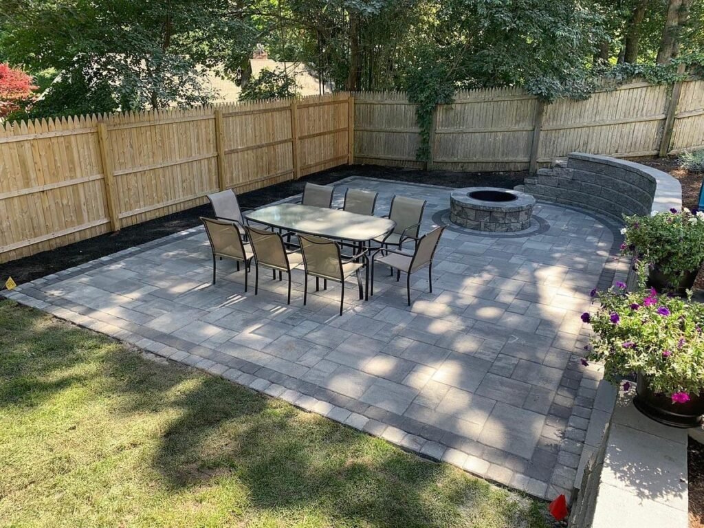 Paver patio with fire pit and dining area built by Bridi Masonry in Cape Cod, MA