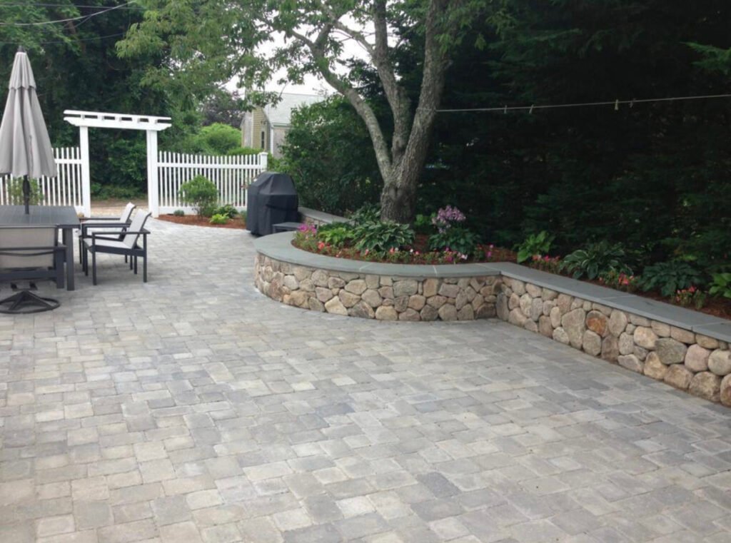 Paver patio with stone seat wall built by Bridi Masonry in Cape Cod, MA