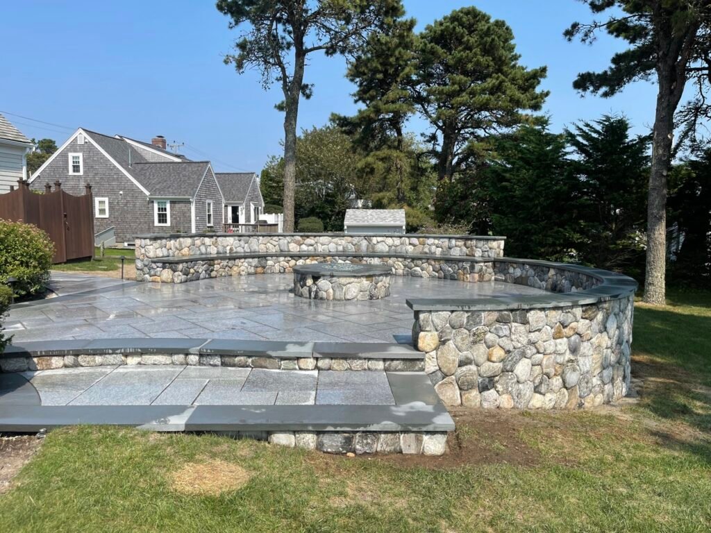 Bluestone patio with stone wall built by Bridi Masonry in Cape Cod, MA