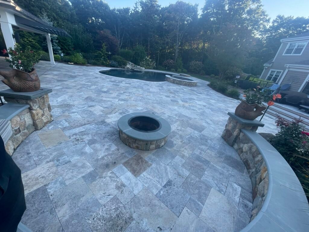 Travertine patio with fire pit built by Bridi Masonry in Cape Cod, MA