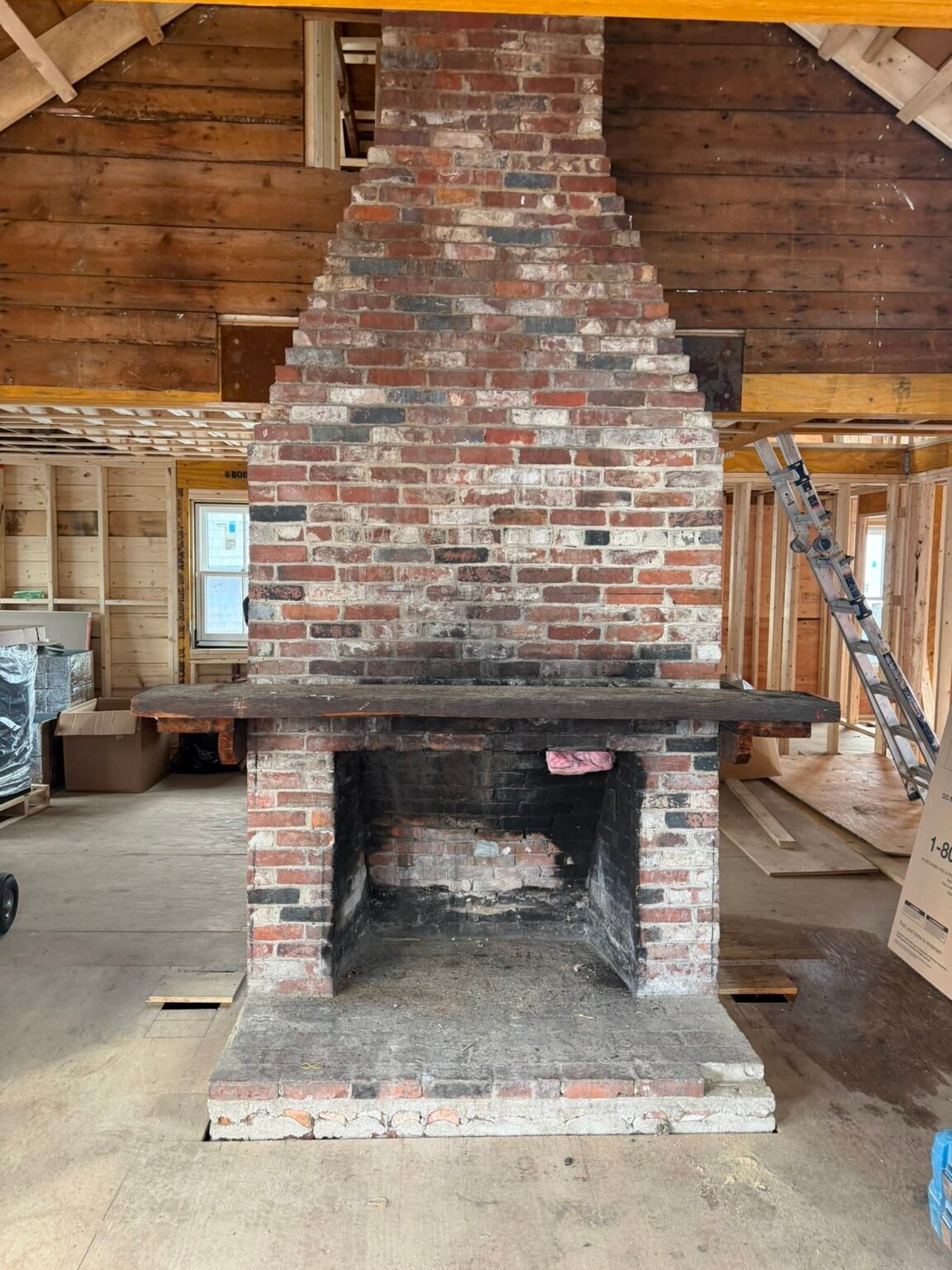 Before: original fireplace with soot-stained firebox and worn mortar joints