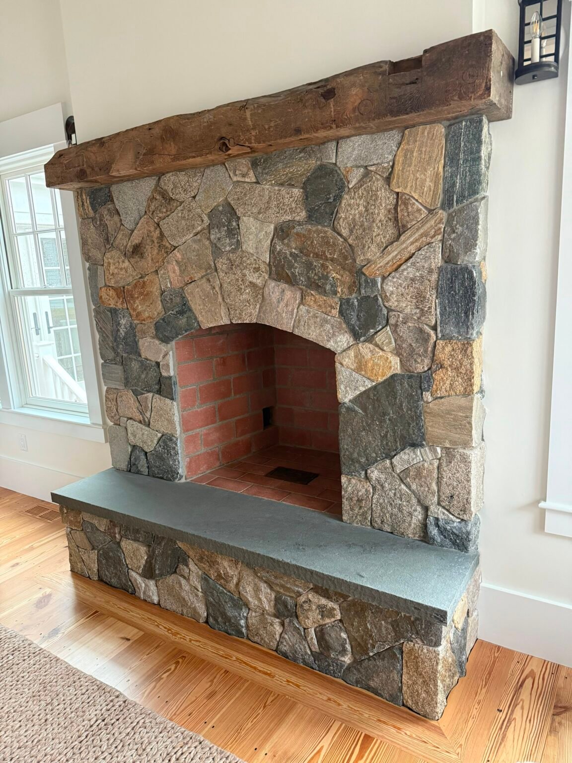 Outdoor fireplace with brick firebox built by Bridi Masonry in Cape Cod, MA